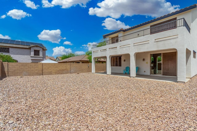 12023 W Duane Ln, Peoria, AZ 85383 - back of house featuring a balcony, stucco siding, a patio area, a fenced backyard, and a tile roof