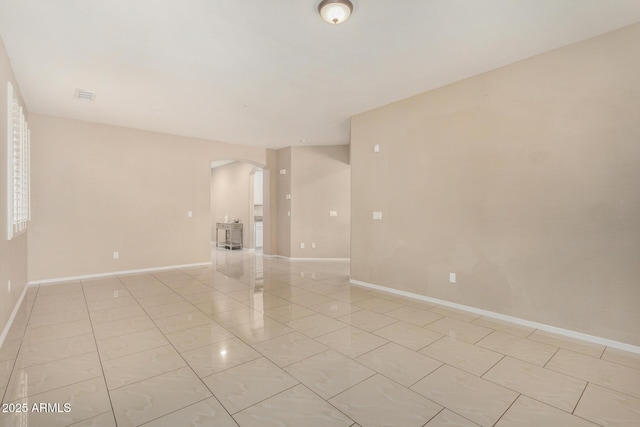 12023 W Duane Ln, Peoria, AZ 85383 - spare room with arched walkways, baseboards, and light marble finish floors