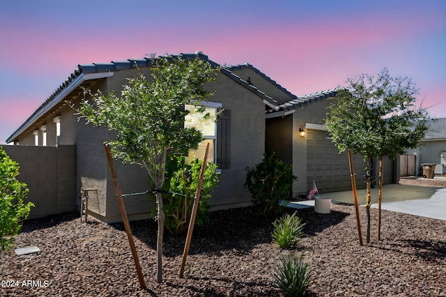 property exterior at dusk featuring a garage