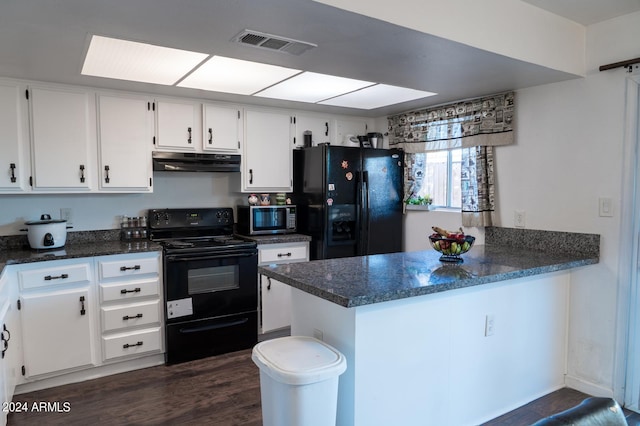 kitchen with dark wood-type flooring, dark stone counters, black appliances, kitchen peninsula, and white cabinetry