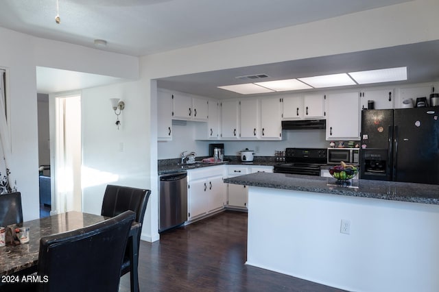 kitchen featuring dark hardwood / wood-style flooring, dark stone counters, sink, black appliances, and white cabinets