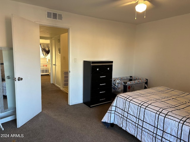 bedroom with radiator heating unit, dark carpet, and ceiling fan