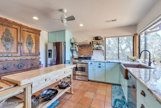 kitchen featuring visible vents, appliances with stainless steel finishes, under cabinet range hood, open shelves, and a sink