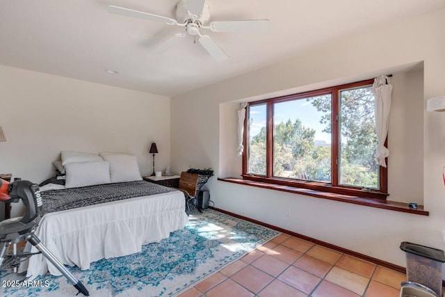 bedroom featuring a ceiling fan, light tile patterned flooring, and baseboards