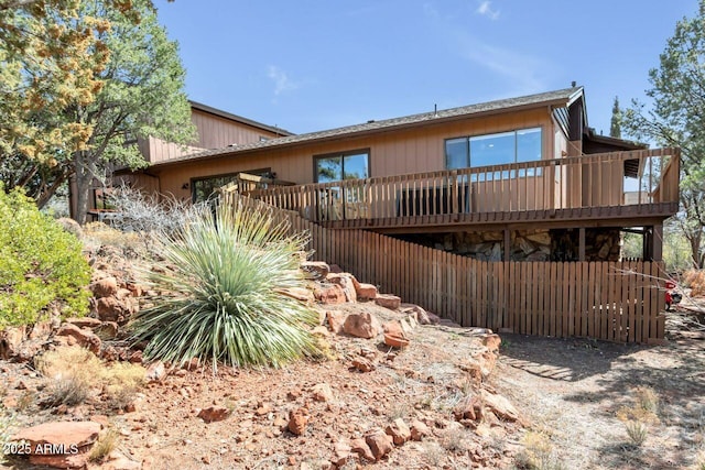 back of property with a deck and stairs