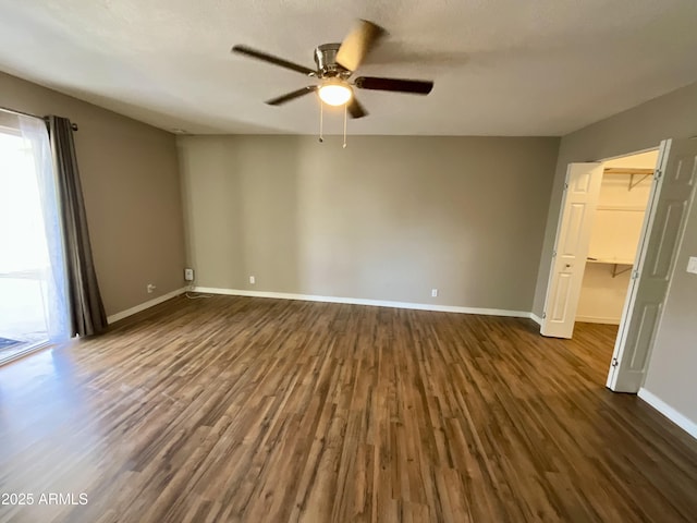 spare room with dark hardwood / wood-style floors and ceiling fan