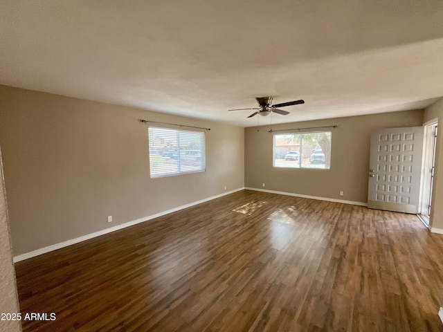 spare room featuring ceiling fan, a healthy amount of sunlight, and dark hardwood / wood-style floors