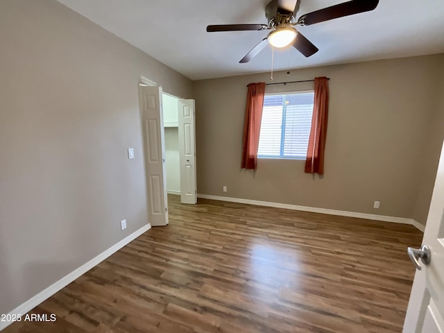 unfurnished bedroom featuring ceiling fan and dark hardwood / wood-style flooring