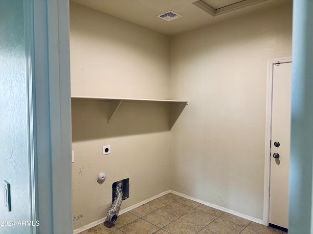 laundry room with electric dryer hookup and light tile patterned floors