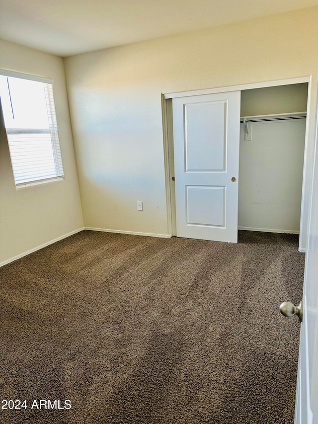 unfurnished bedroom with carpet flooring and a closet