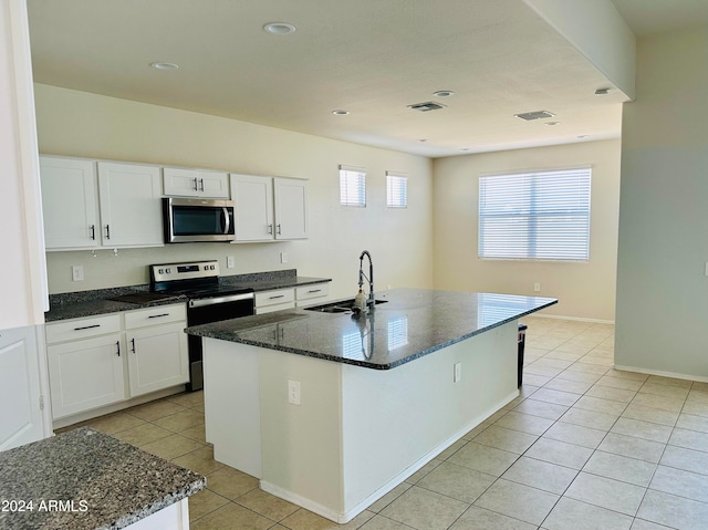 kitchen featuring white cabinets, sink, stainless steel appliances, and a center island with sink