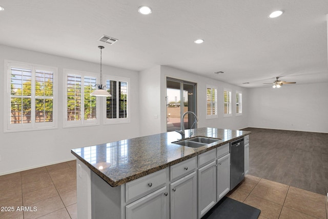 kitchen featuring decorative light fixtures, a center island with sink, open floor plan, a sink, and dishwasher