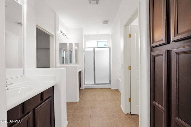 full bath with visible vents, vanity, a closet, a shower stall, and tile patterned floors