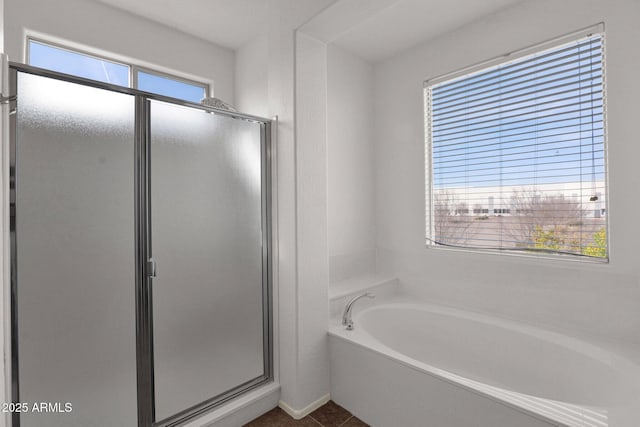 full bathroom featuring a garden tub, a shower stall, and tile patterned flooring