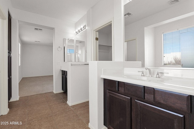 full bathroom featuring two vanities, visible vents, and a sink