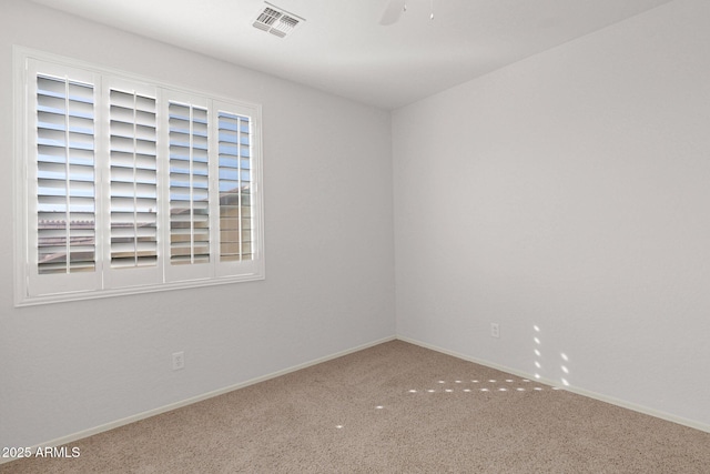 unfurnished room featuring carpet floors, visible vents, ceiling fan, and baseboards