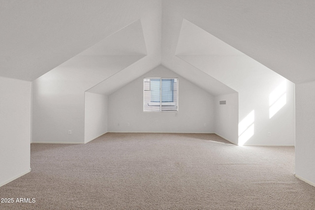 bonus room featuring lofted ceiling and light carpet