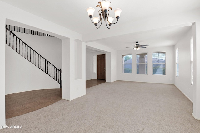 interior space with ceiling fan with notable chandelier, stairway, carpet, and tile patterned floors