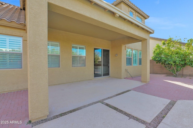 exterior space with a patio, a tile roof, and stucco siding