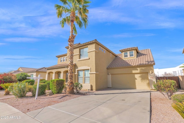 mediterranean / spanish-style home with a garage, driveway, a tile roof, fence, and stucco siding