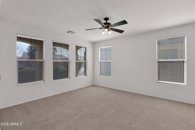 spare room featuring a ceiling fan, carpet flooring, visible vents, and baseboards