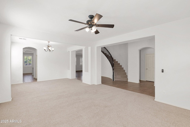 empty room with light carpet, arched walkways, and visible vents