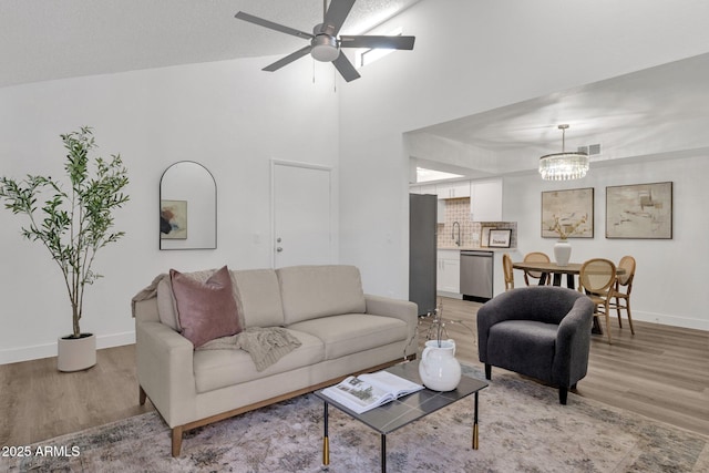 1075 E Chandler Blvd Unit 212, Chandler, AZ 85225 - living room with light wood-style floors, a chandelier, ceiling fan, and a high ceiling