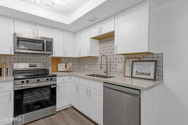 1075 E Chandler Blvd Unit 212, Chandler, AZ 85225 - kitchen with appliances with stainless steel finishes, light countertops, white cabinets, and decorative backsplash