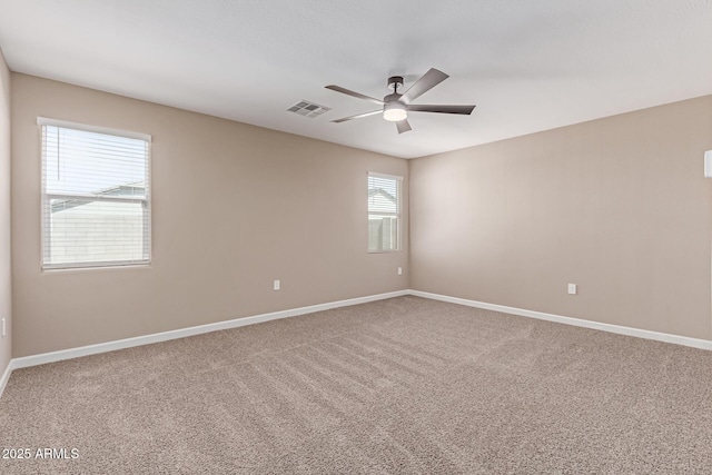 carpeted empty room with a ceiling fan, baseboards, and visible vents
