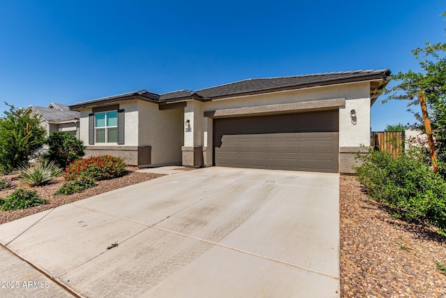 prairie-style house with stucco siding, an attached garage, driveway, and a tile roof