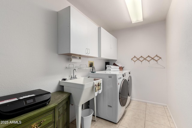 laundry area featuring washing machine and clothes dryer, light tile patterned flooring, and cabinets