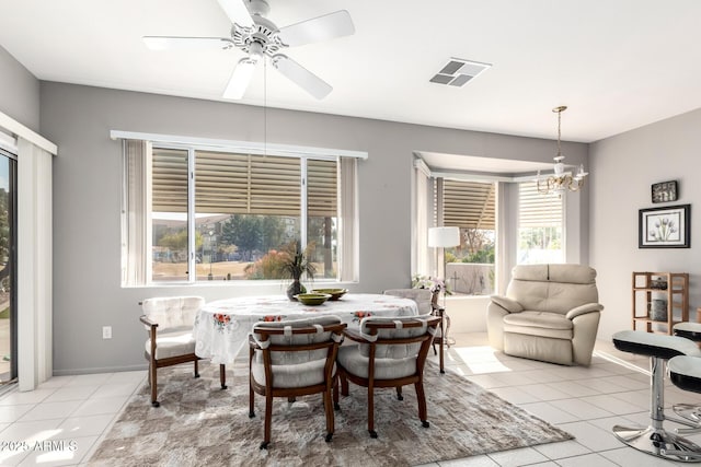 dining space featuring ceiling fan with notable chandelier and light tile patterned floors