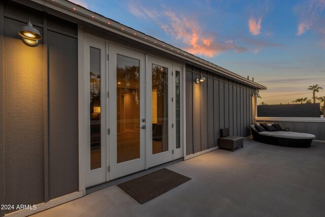 pool at dusk featuring ceiling fan, a patio area, and an outdoor living space with a fire pit