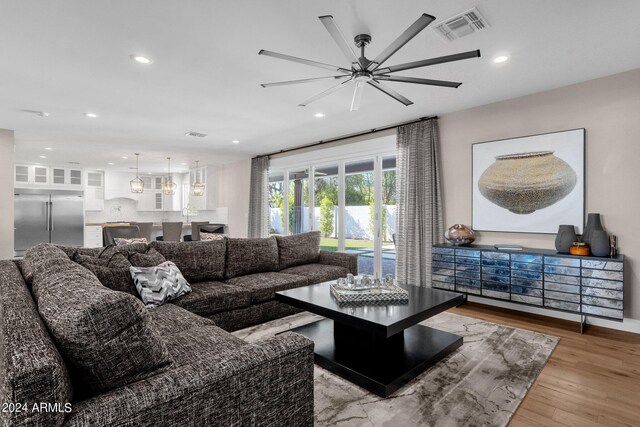 living room featuring ceiling fan and light hardwood / wood-style flooring