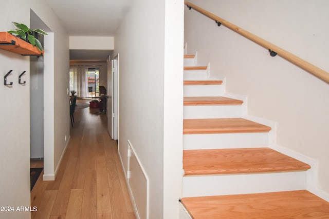 stairway with light hardwood / wood-style flooring