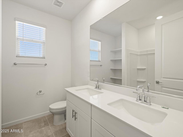 bathroom with tile patterned flooring, vanity, and toilet