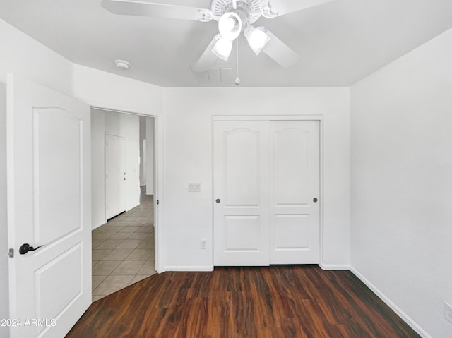 unfurnished bedroom featuring ceiling fan, a closet, and dark hardwood / wood-style floors