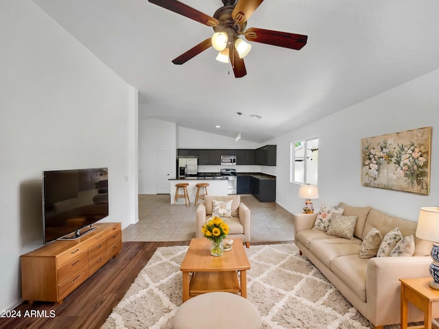 living room with dark hardwood / wood-style floors, ceiling fan, and lofted ceiling