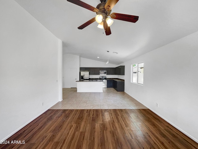 unfurnished living room featuring light wood-type flooring, vaulted ceiling, and ceiling fan