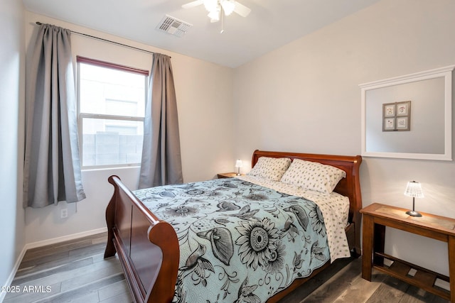 bedroom with ceiling fan, wood finished floors, visible vents, and baseboards