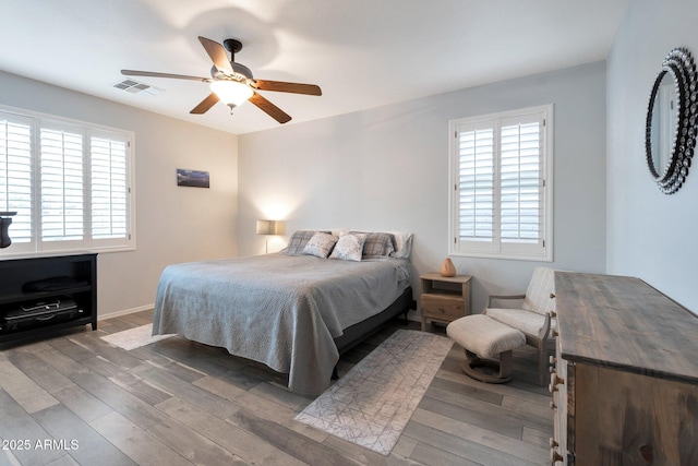 bedroom featuring ceiling fan, visible vents, and wood finished floors