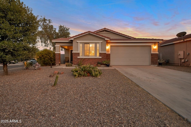 single story home with driveway, brick siding, an attached garage, and stucco siding