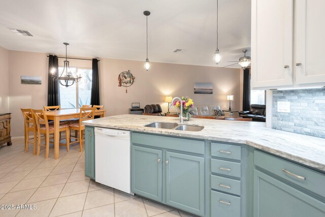 kitchen featuring tasteful backsplash, visible vents, a peninsula, white dishwasher, and a sink