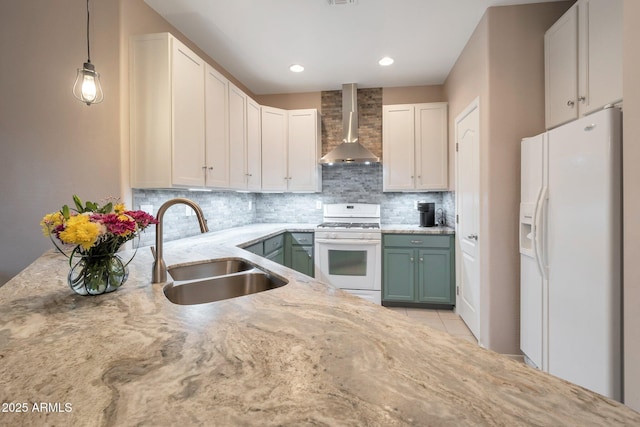 kitchen featuring white appliances, tasteful backsplash, wall chimney exhaust hood, light stone countertops, and a sink