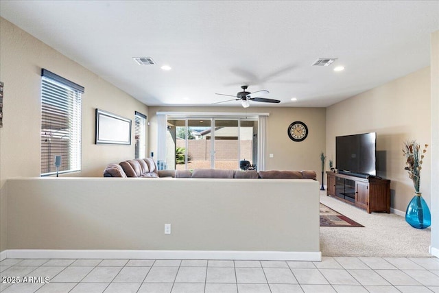 unfurnished living room featuring light tile patterned floors, visible vents, baseboards, and ceiling fan