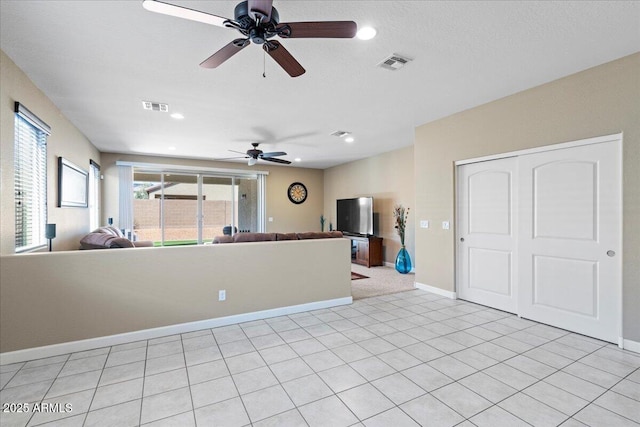 unfurnished living room with light tile patterned floors, visible vents, and baseboards