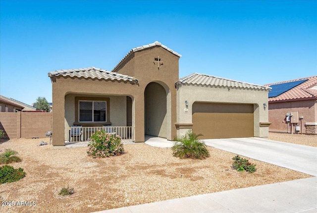 mediterranean / spanish-style house with driveway, covered porch, stucco siding, a garage, and a tiled roof