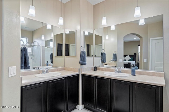 ensuite bathroom with a sink, ensuite bathroom, two vanities, and a shower stall