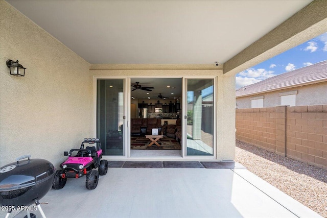 entrance to property featuring stucco siding and fence