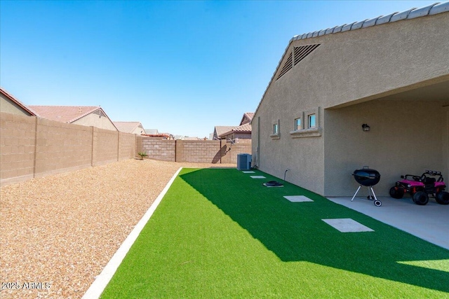 view of yard with central air condition unit, a patio, and a fenced backyard